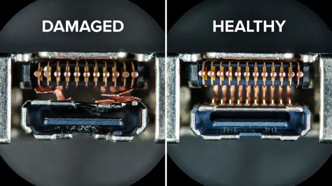 Microscope comparison photo showing bent pins in a damaged Switch charging port versus a healthy port