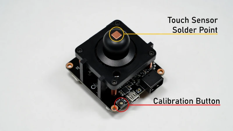 Macro view of GuliKit Hall Effect joystick module highlighting the calibration button and touch sensor solder pad.
