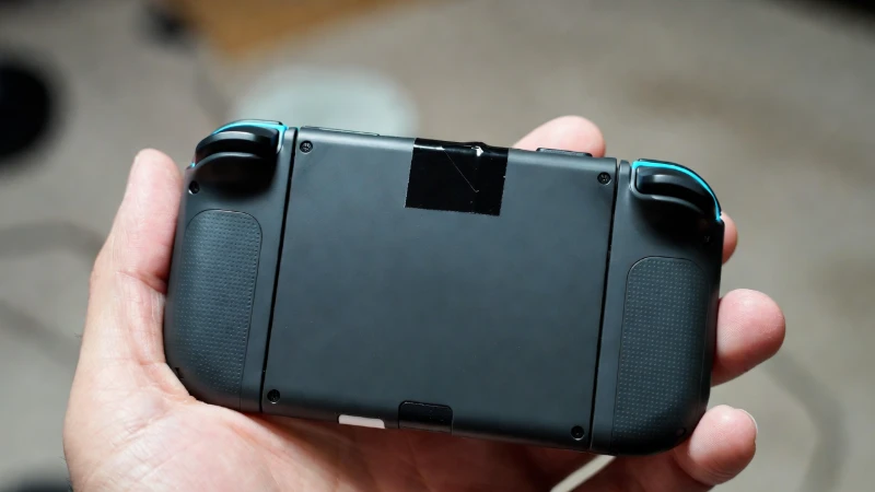 Placing a small shim behind a Joy-Con rail to fix connection issues